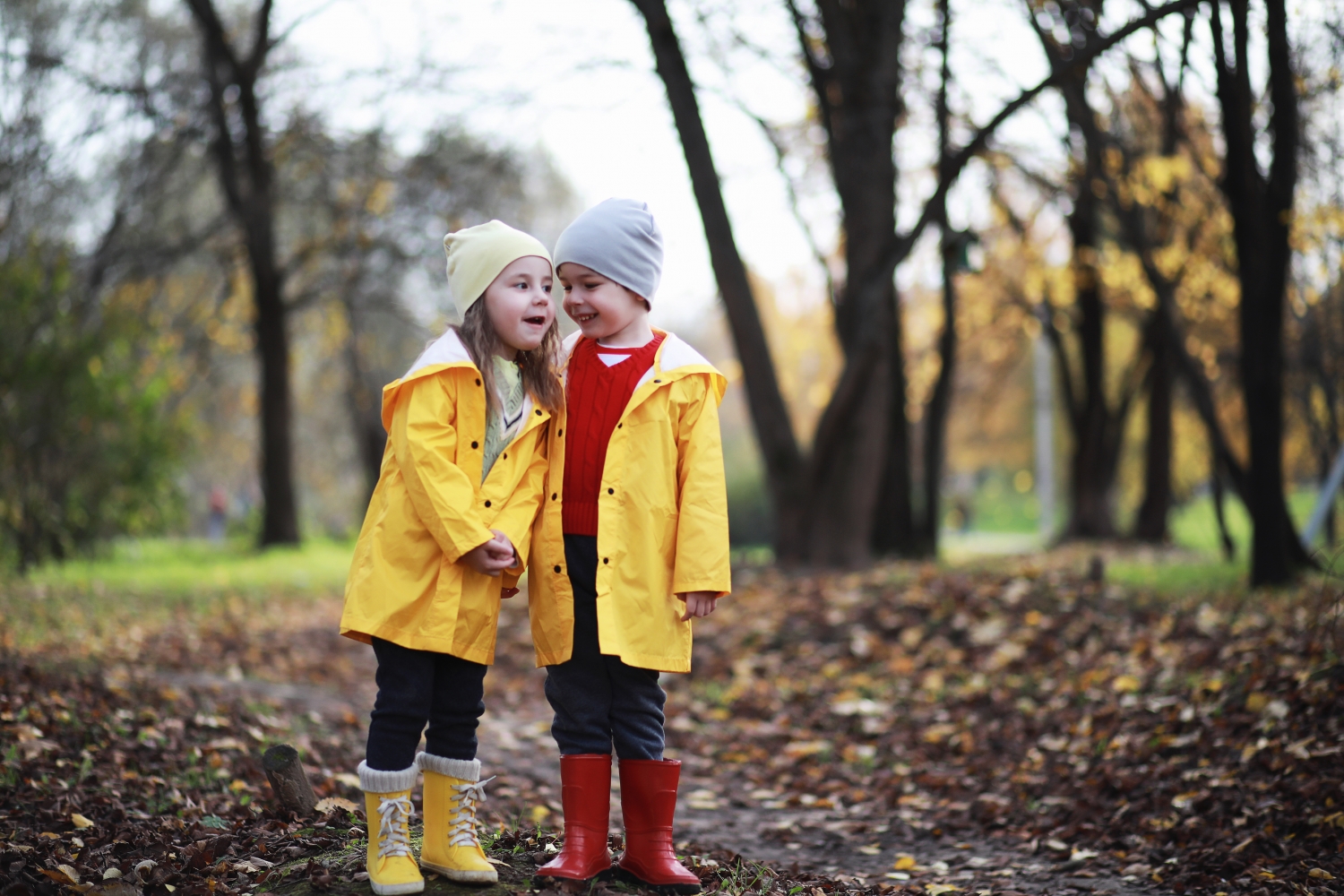 2 kinderen in regenkleding in het bos